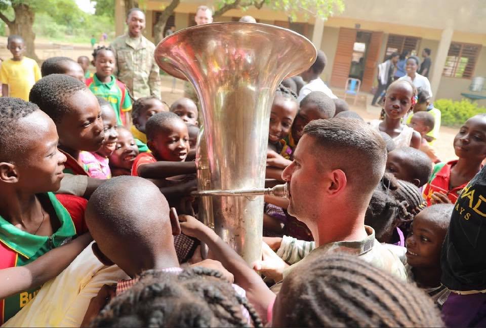Man playing Tuba in a crowd of children